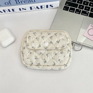 Detail of floral quilted mini pouch with metal ring zipper and snap button pocket