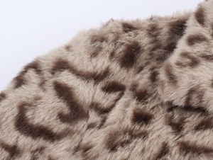Detailed macro view of the soft faux fur leopard print texture on the long coat fabric