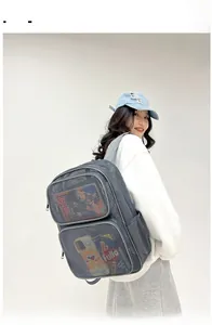 Detail view of grey breathable mesh backpack with multiple zippered pockets on female model