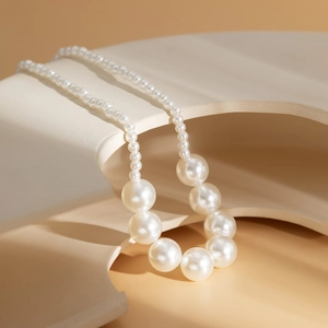 Macro detail of elegant cream white layered pearl necklace with gradient bead sizing