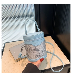 Detail of light blue PU leather and lace bucket bag with zip and logo engraving
