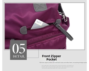Detailed macro view of the purple nylon handbag's front zipper pocket and stitching
