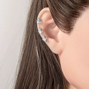 Three silver kitten stud earrings with blue heart zircon stones on a model ear
