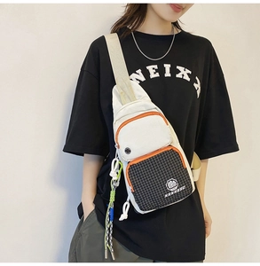 Detailed view of a casual canvas chest bag with multi-pocket design on a person