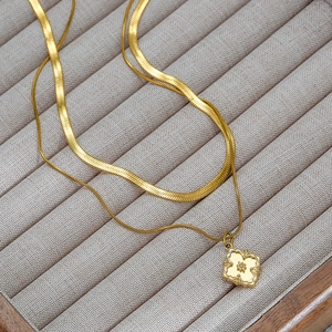 Detail view of double-layer 18k gold plated necklace with square vintage pendant