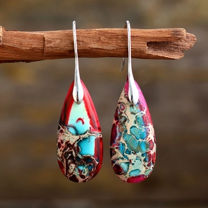 Detailed view of Bohemian teardrop earrings with multi-color stone textures on wood
