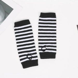Detail shot of black and white striped knitted arm warmer featuring a thumb hole design