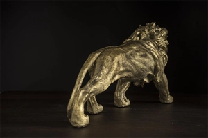 Detailansicht der goldenen Löwenstatue mit Fokus auf Muskellinien und Mähnenstruktur