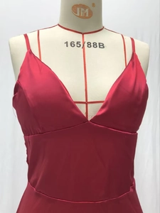 Détail de la robe rouge en satin avec col en V, texture soyeuse et taille haute chic