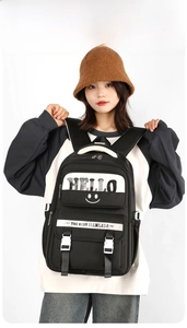 Detail of large capacity black student backpack featuring a white Hello print and buckle straps