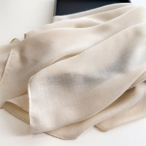 Close-up of soft beige cotton linen scarf showing lightweight texture and fine weaving