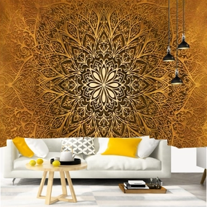 Detail of a large gold mandala tapestry hung behind a sofa in a modern living room scene