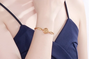 Nahaufnahme des goldenen Unendlichkeit-Armbands mit Gliederkette am Handgelenk