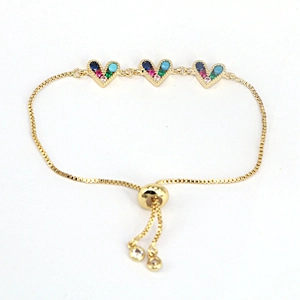 Detail of adjustable gold bracelet featuring three heart charms set with multi-color zircons