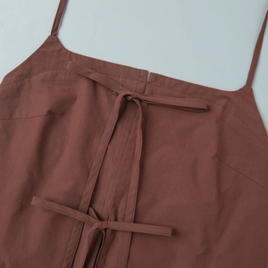 Detail of brown halter top featuring delicate ribbon bow ties and fine stitching