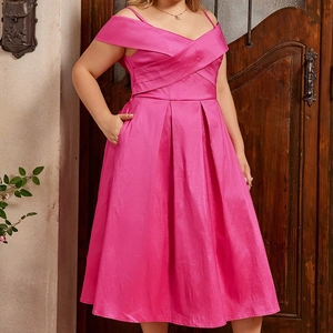 Détail d'une robe grande taille rose fuchsia avec décolleté en V et taille croisée