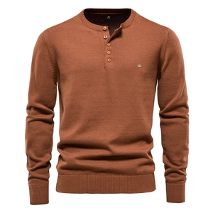 Detailed view of caramel knit sweater featuring classic henley neckline and ribbed textures
