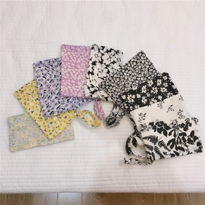 Vue à plat de pochettes en tissu à motifs floraux variés avec dragonnes de transport