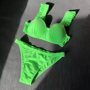 Detail view of neon green bikini top with ruffled straps and pleated underwire cups