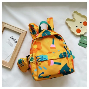 Close-up of a yellow floral child backpack with a matching round coin purse accessory