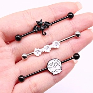 Detailed view of industrial barbell studs featuring bat, flower, and skull designs