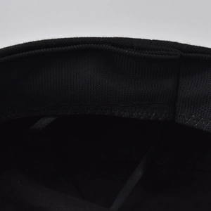 Detailed macro view of the inner sweatband and stitching on a black newsboy cap