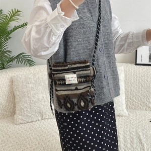 Close-up of heart patterned plush crossbody bag with ethnic print and braided rope strap