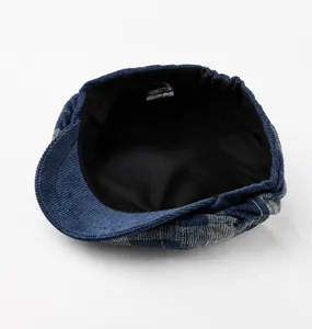 Détail d'une casquette en velours bleu montrant la doublure et l'étiquette 100% coton