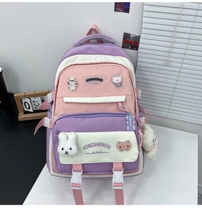 Close-up of a pastel patchwork backpack with cute cartoon badges and a plush bunny charm