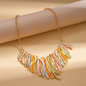 Détail de pendentifs en émail ondulé coloré sur un collier pull doré pour femme