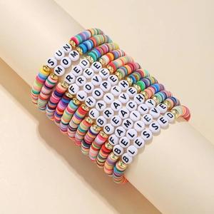 Macro shot of 12 colorful clay bead friendship bracelets with letters on a display