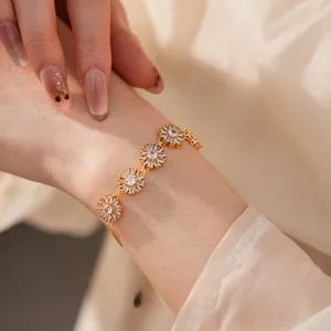 Detail of adjustable gold flower bracelet featuring sparkling zircon daisy charms