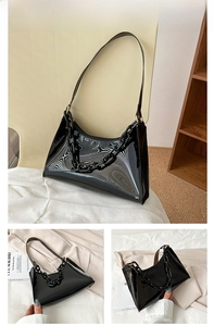 Detail of black glossy underarm bag with thick plastic chain and retro minimalist design