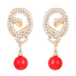 Detail of twisted gold snake earrings with inlaid crystals and large red round beads