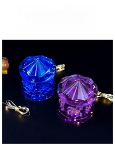 Detailed view of blue and purple resin carousel ornaments with warm LED string lights