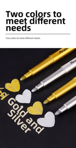 Close-up of gold and silver metallic markers writing on black paper with glossy finish