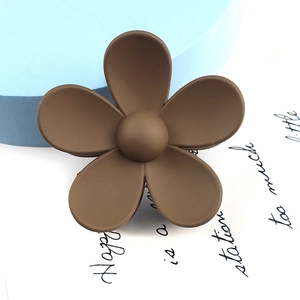 Detailed macro view of a large matte brown flower hair claw clip with five rounded petals