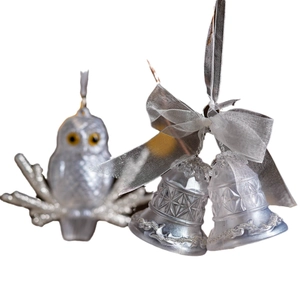 Sparkling silver Christmas bell ornaments with ribbons and owl pendant on white background