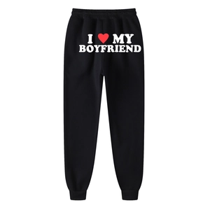Black joggers with I Love My Boyfriend print and red heart design in a flat lay view