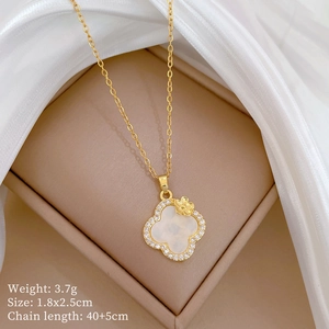 Macro view of clover pendant with white shell and crystals on gold steel chain