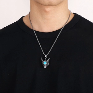 Silver punk dragon skull necklace with turquoise stone inlay worn on a black shirt