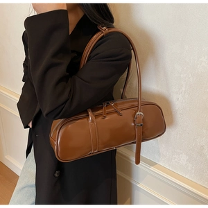 Detailed view of a brown vintage baguette bag with sleek leather finish and silver hardware