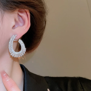 Close-up of model wearing silver zircon hoop earrings with rectangular and round stones