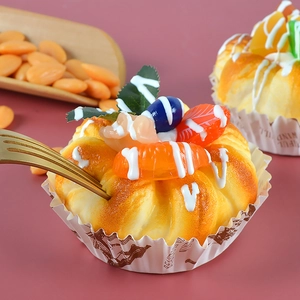 Macro shot of realistic artificial fruit cupcake with orange slices and golden frosting
