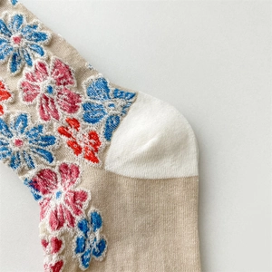 Close-up of retro floral embossed knit socks with colorful 3D embroidery detail