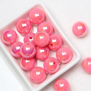 Macro shot of 16mm pink acrylic colorful beads with iridescent finish for DIY crafts