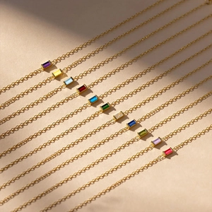 Macro detail of gold-plated bracelets featuring colorful rectangular zircon gemstones