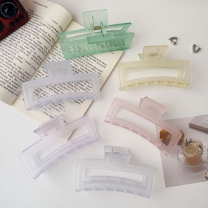 Pastel matte large shark hair clips set in diverse colors on a white minimalist desk