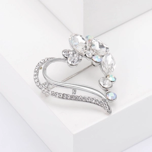 Macro detail of silver heart brooch with multi-cut crystals and AB rainbow shimmer gems