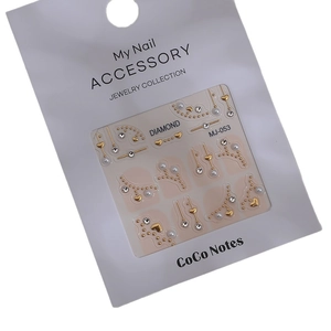 Water drop nail art decoration set with gold beads, rhinestones, and pearls on white card